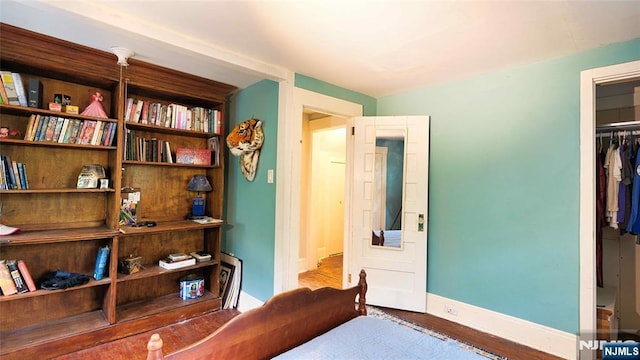 bedroom featuring wood finished floors, a closet, and baseboards
