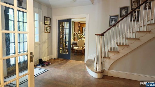 foyer featuring french doors, baseboards, and stairway
