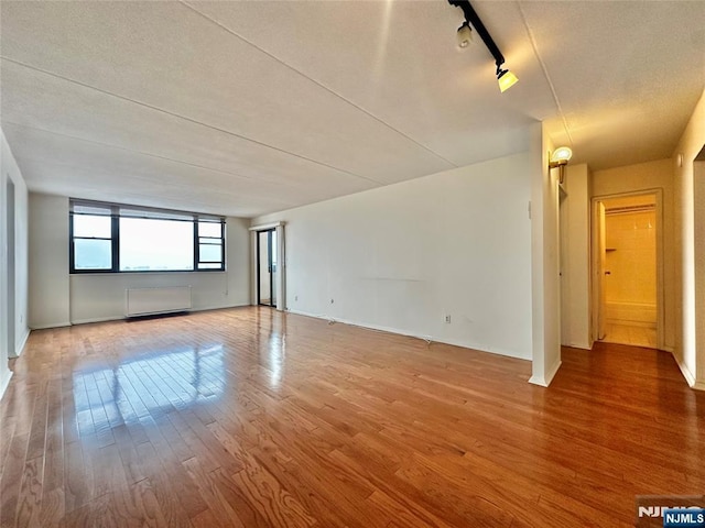 250 Gorge Unit 23A, Cliffside Park, NJ 07010 - empty room featuring wood finished floors, track lighting, and baseboards