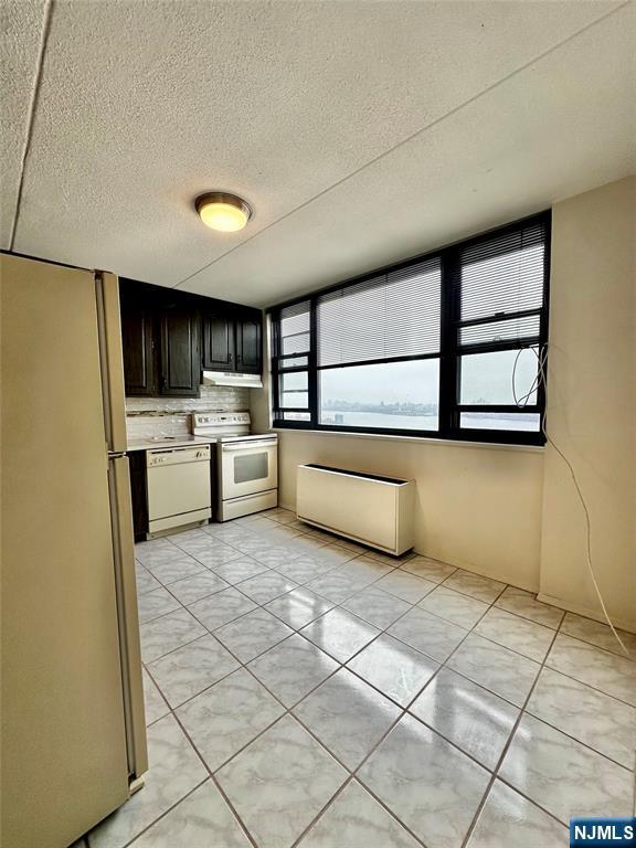 250 Gorge Unit 23A, Cliffside Park, NJ 07010 - kitchen with white appliances, extractor fan, tasteful backsplash, light tile patterned floors, and a textured ceiling