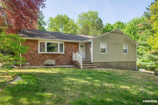 ranch-style house featuring a front lawn and brick siding