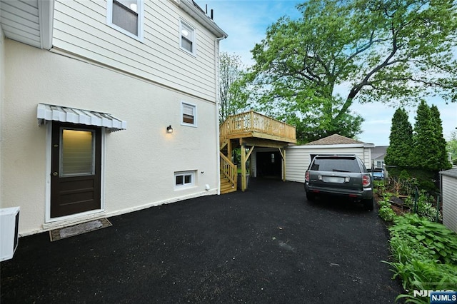 view of home's exterior with stucco siding, stairs, and a deck