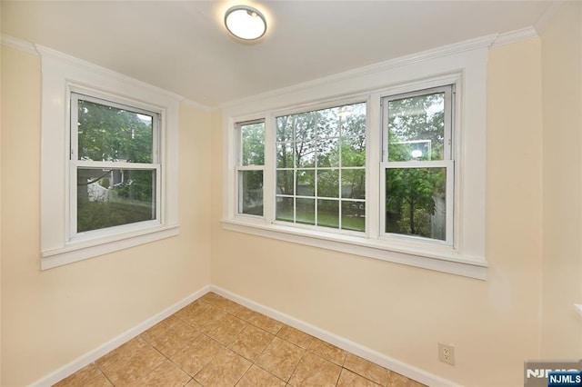 unfurnished room featuring baseboards, light tile patterned floors, and ornamental molding