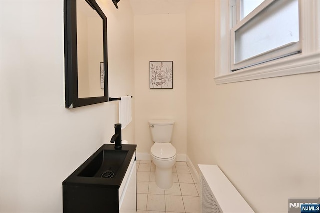 bathroom with toilet, tile patterned floors, baseboards, and vanity