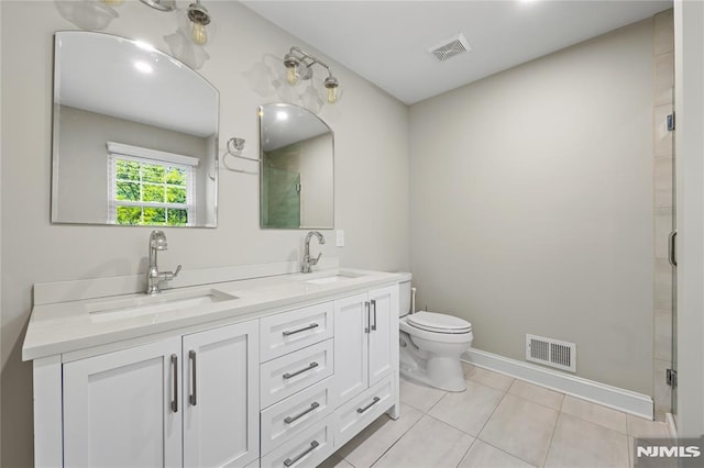 full bathroom with a shower stall, tile patterned floors, double vanity, toilet, and baseboards