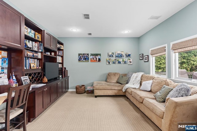 living area with light colored carpet and baseboards