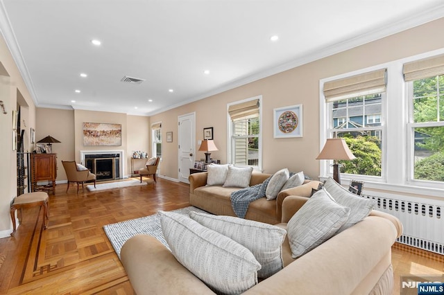 living room featuring radiator, healthy amount of natural light, ornamental molding, recessed lighting, and baseboards