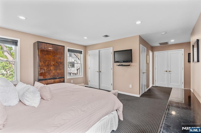 bedroom with baseboards, two closets, and recessed lighting