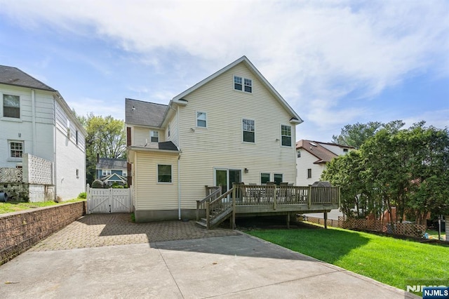 back of property with a gate and a wooden deck