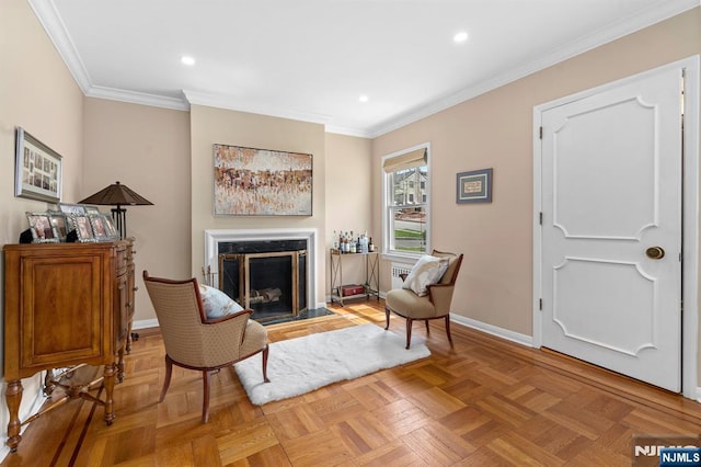 sitting room with recessed lighting, crown molding, baseboards, and a premium fireplace