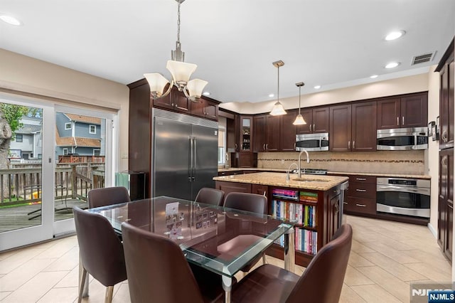 kitchen featuring stainless steel appliances, decorative backsplash, a chandelier, light tile patterned floors, and recessed lighting
