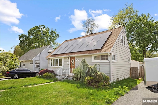 186 10th Ave, Hawthorne, NJ 07506 - view of front facade featuring roof mounted solar panels, a front lawn, and a shingled roof