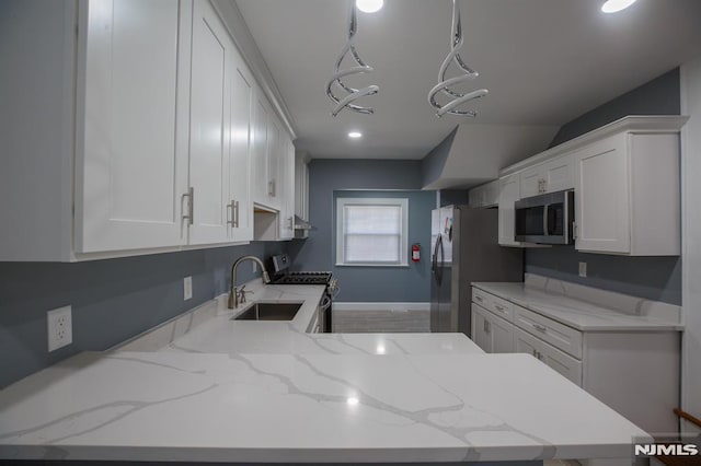 kitchen with stainless steel appliances, a sink, white cabinetry, light stone counters, and recessed lighting