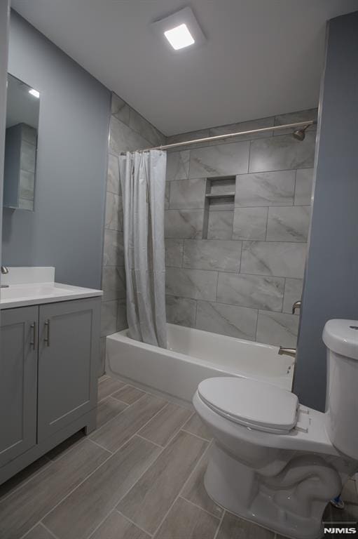 bathroom with toilet, shower / tub combo, and vanity