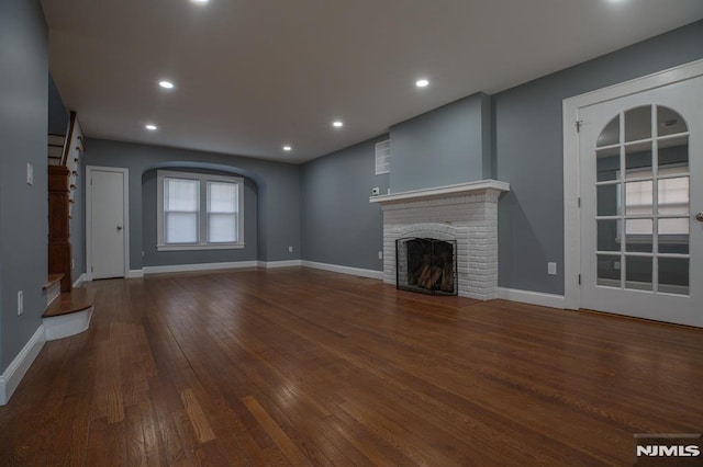 unfurnished living room with wood finished floors, a fireplace, baseboards, and recessed lighting