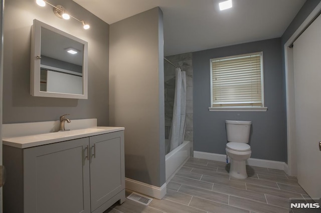 bathroom with baseboards, toilet, vanity, wood finish floors, and shower / tub combo with curtain