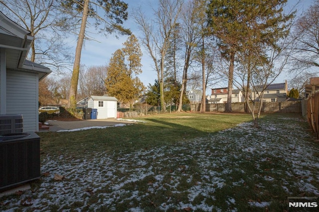 view of yard featuring a storage shed, an outdoor structure, central AC, and a residential view