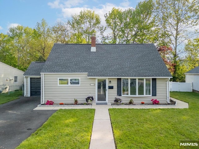 cape cod-style house featuring a shingled roof, a chimney, a garage, and driveway
