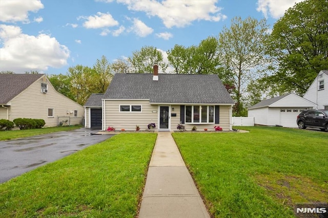 view of front facade with asphalt driveway, a chimney, and a garage