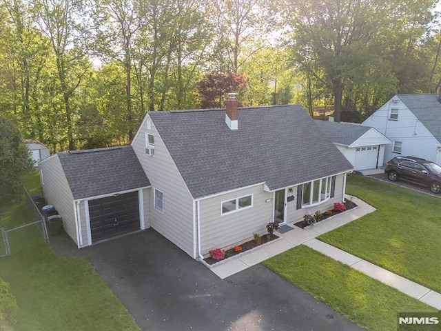 view of front facade with asphalt driveway, a shingled roof, a garage, and a chimney
