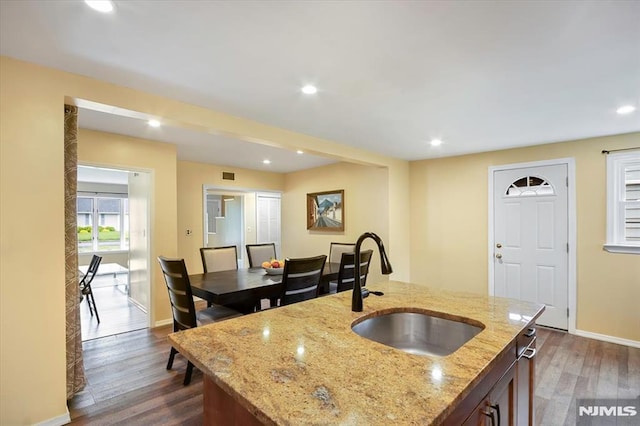 kitchen featuring a sink, dark wood finished floors, baseboards, recessed lighting, and light stone countertops