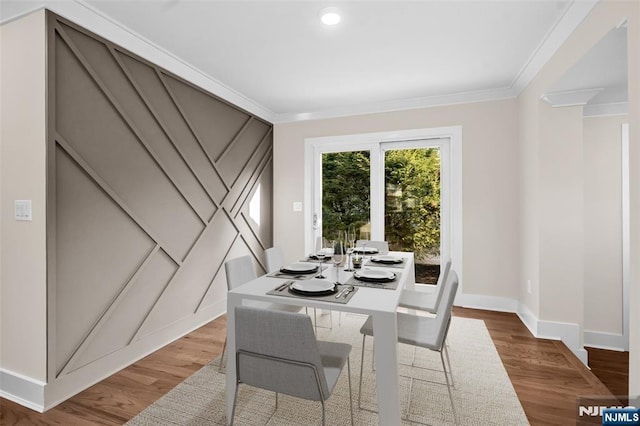 dining space featuring baseboards, crown molding, wood finished floors, and recessed lighting