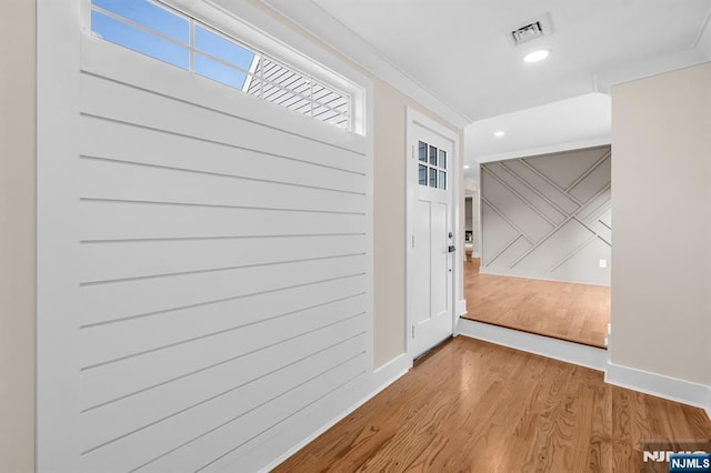 doorway to outside featuring baseboards, wood finished floors, recessed lighting, and ornamental molding