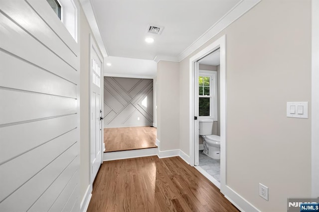 corridor featuring baseboards, wood finished floors, ornamental molding, and recessed lighting