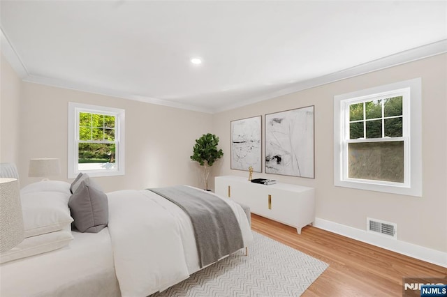 bedroom featuring baseboards, crown molding, light wood-style flooring, and recessed lighting