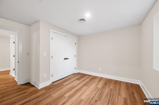 unfurnished bedroom with light wood-style flooring and baseboards