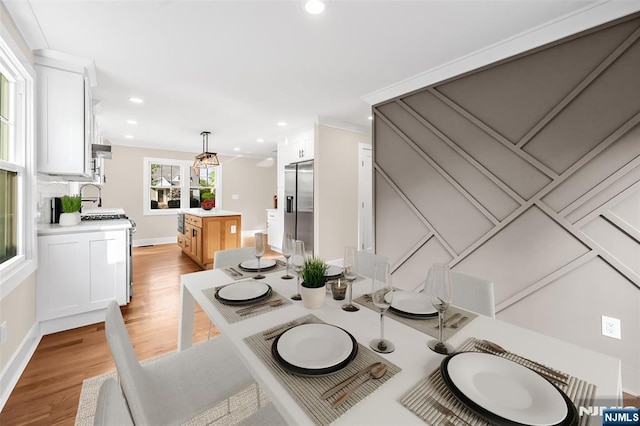 dining room with light wood finished floors, recessed lighting, baseboards, and ornamental molding
