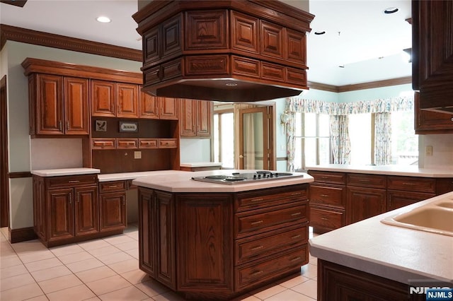 kitchen with premium range hood, electric cooktop, light tile patterned floors, ornamental molding, and a center island