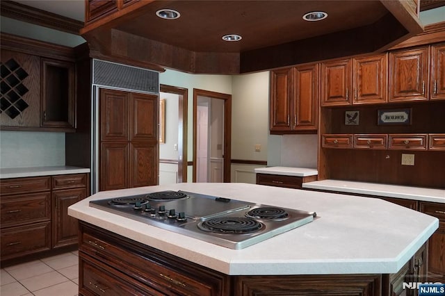 kitchen featuring paneled built in refrigerator, stainless steel electric cooktop, light countertops, a center island, and recessed lighting