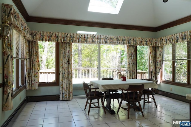 dining room with crown molding, healthy amount of natural light, light tile patterned floors, lofted ceiling, and a skylight