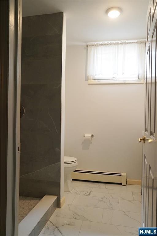 bathroom featuring baseboard heating, marble look tile flooring, toilet, a stall shower, and baseboards
