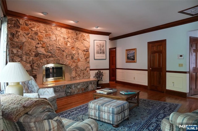 living room with crown molding, wood finished floors, and wainscoting