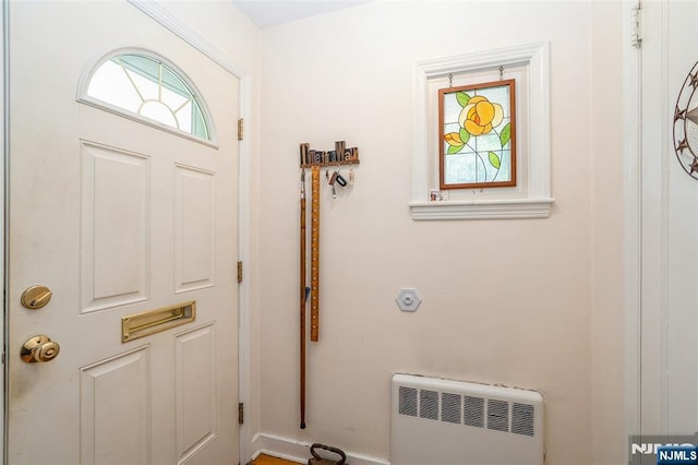 doorway to outside with radiator and heating unit