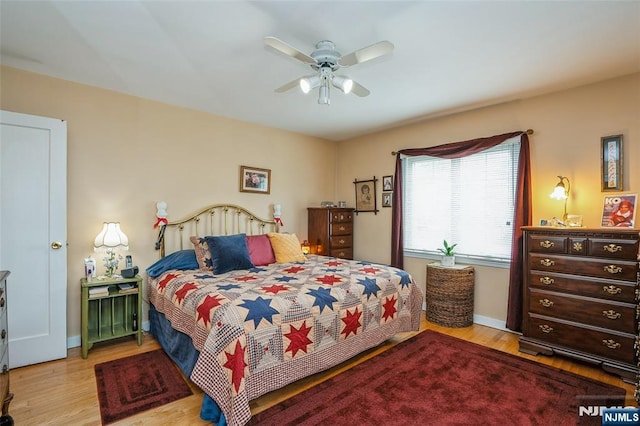 bedroom with wood finished floors, baseboards, and ceiling fan