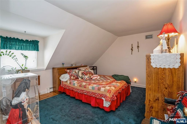 bedroom featuring baseboard heating and lofted ceiling