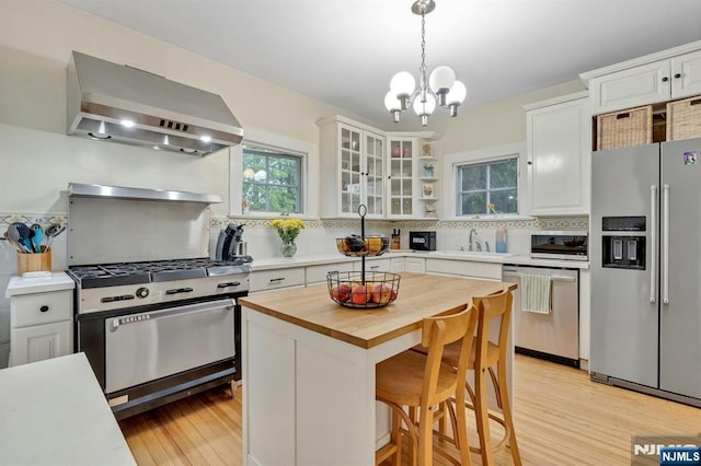 121 Beverly Rd, Montclair, NJ 07043 - kitchen with appliances with stainless steel finishes, wall chimney exhaust hood, butcher block countertops, tasteful backsplash, and a sink