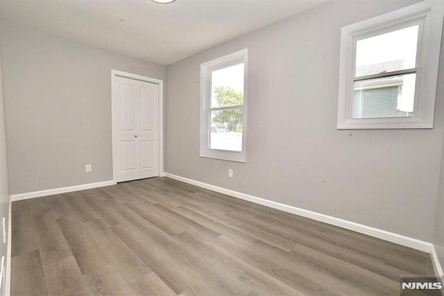 spare room with wood finished floors and baseboards
