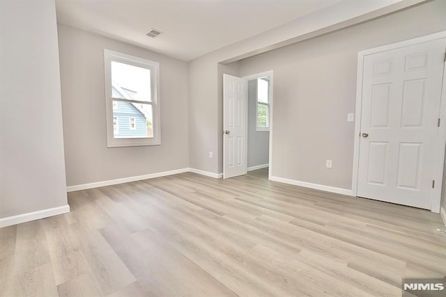 empty room with baseboards and light wood-style flooring