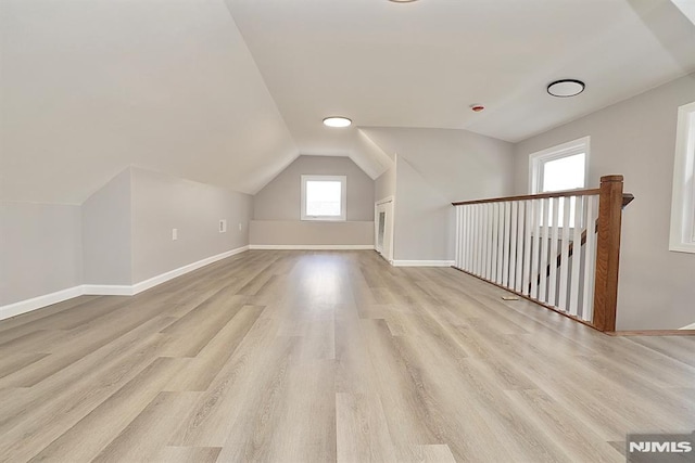 bonus room with wood finished floors, vaulted ceiling, and baseboards