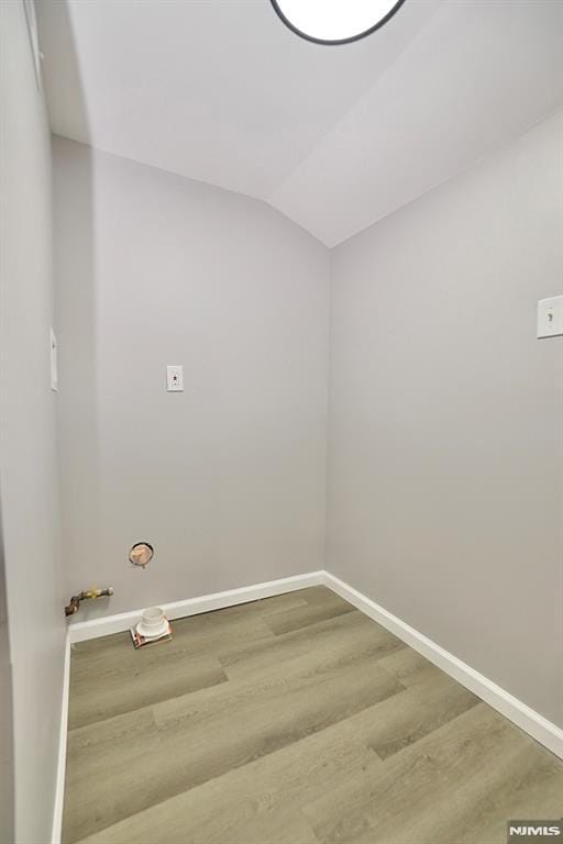 laundry area with wood finished floors and baseboards