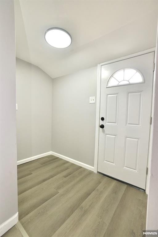 foyer entrance with wood finished floors and baseboards