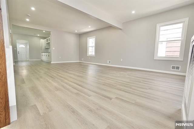 unfurnished living room featuring light wood finished floors, baseboards, and recessed lighting