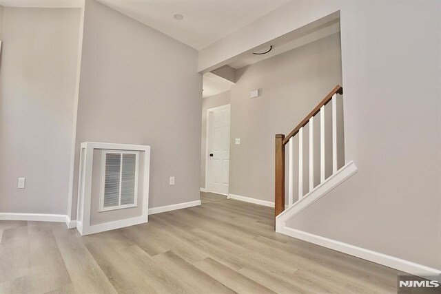 foyer entrance featuring stairway, wood finished floors, and baseboards
