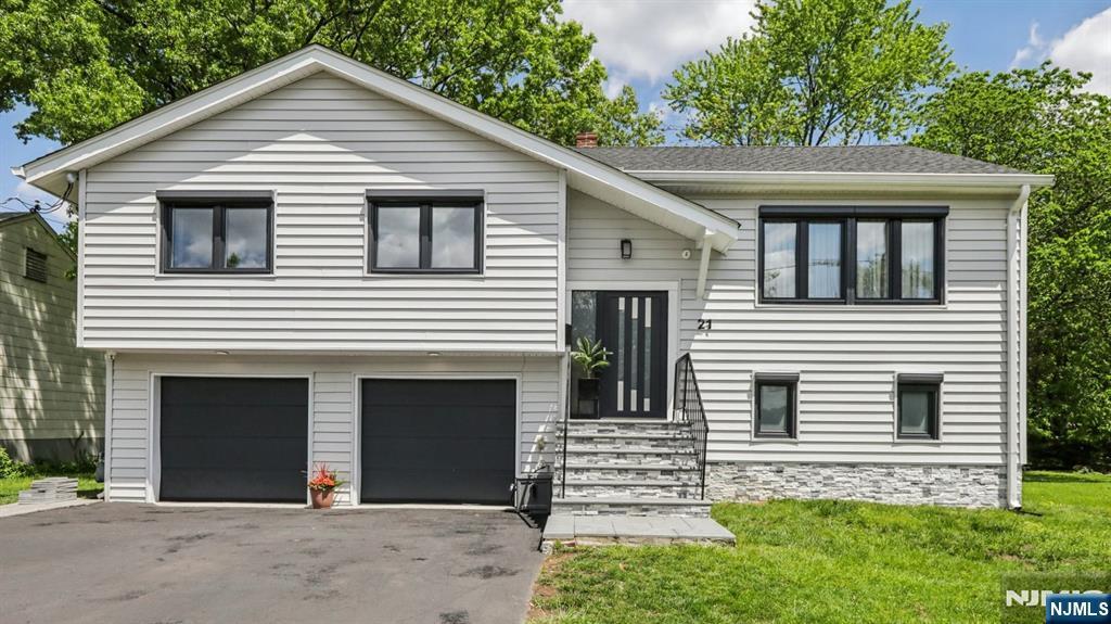 21 Ray Ave, Leonia, NJ 07605 - split foyer home featuring entry steps, driveway, a front yard, and a garage