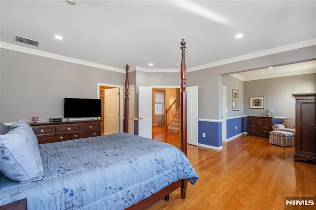 bedroom with crown molding, wood finished floors, baseboards, and recessed lighting