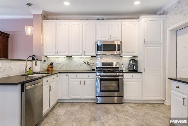 kitchen featuring appliances with stainless steel finishes, a sink, dark countertops, crown molding, and white cabinetry